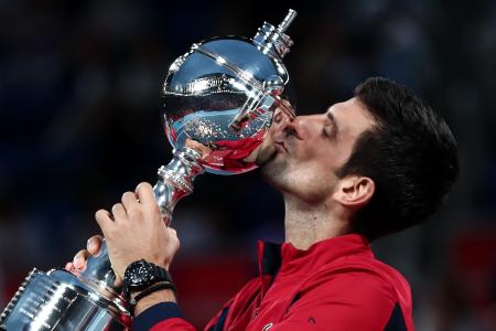 In this file photo taken on October 6, 2019 Serbia's Novak Djokovic kisses the trophy after winning the men's singles final against John Millman of Australia at the Japan Open tennis tournament in Tokyo. (AFP)