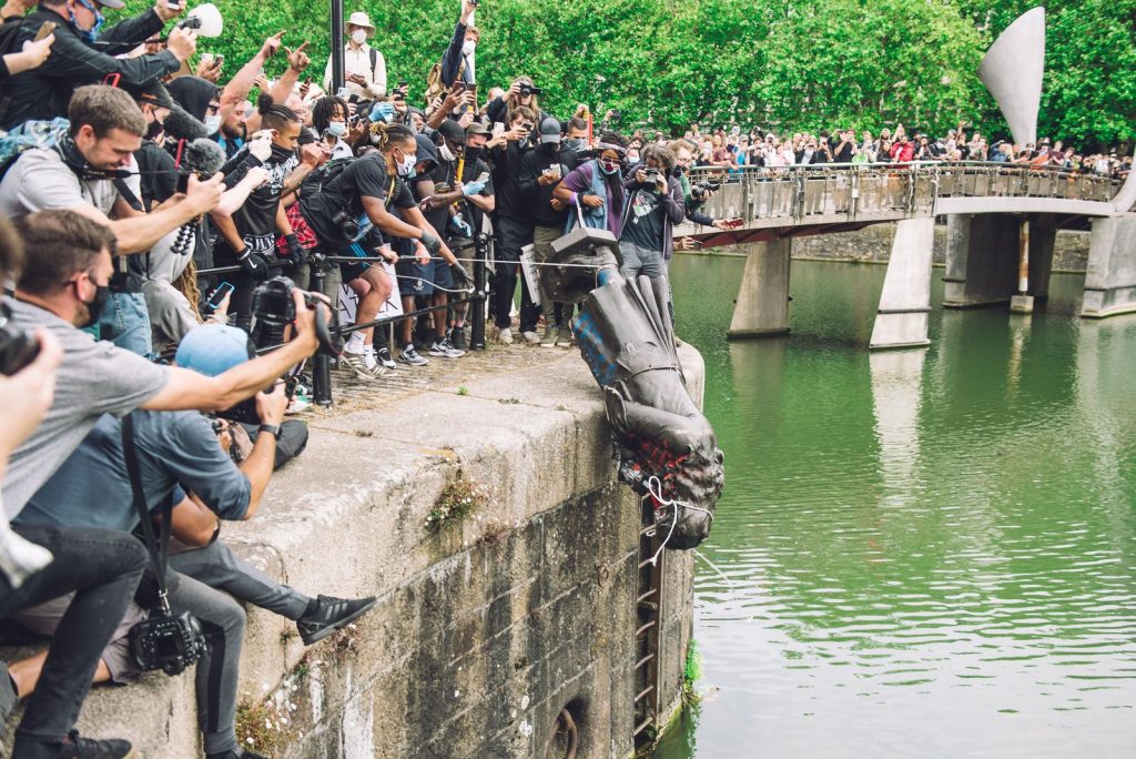 Protesters push a statue of 17th-century slave trader Edward Colston into Bristol Harbor. (Getty Images)