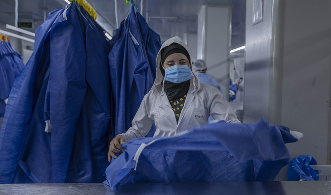 A woman working at Medic Egypt for Medical Clothes company makes protective equipment to be used to help curb the spread of the coronavirus at a factory in Menoufiya, Egypt. (AP)