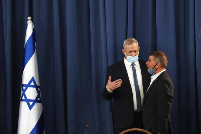 Israeli Defence Minister and Alternate Prime Minister Benny Gantz, wearing a protective face mask, speaks with speaks to Foreign Minister Gabi Ashkenazi during the weekly cabinet meeting in Jerusalem on May 31, 2020. (AFP)