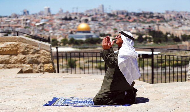A Muslim worshipper offers his Friday prayer outside Jerusalem’s Old City amid the coronavirus restrictions. Al-Aqsa Mosque in the city is one of Islam’s three holy sites. (Reuters)