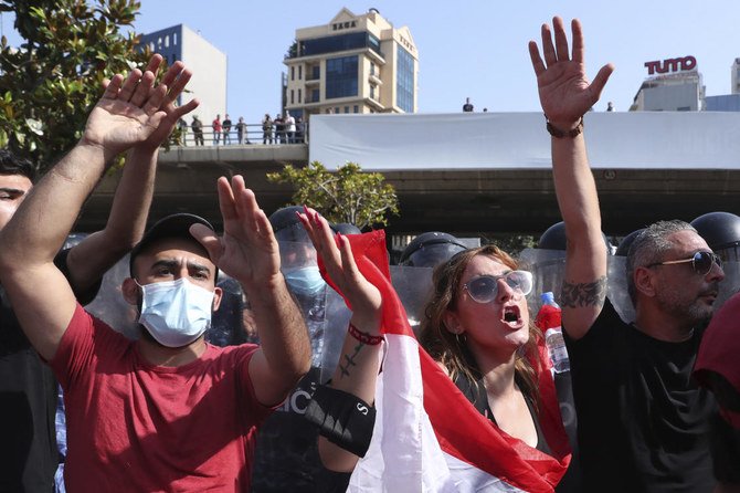 Protesters, protect riot police from stones thrown by anti-government protesters during a protest in downtown Beirut, Lebanon, Saturday, June 6, 2020. (AP)