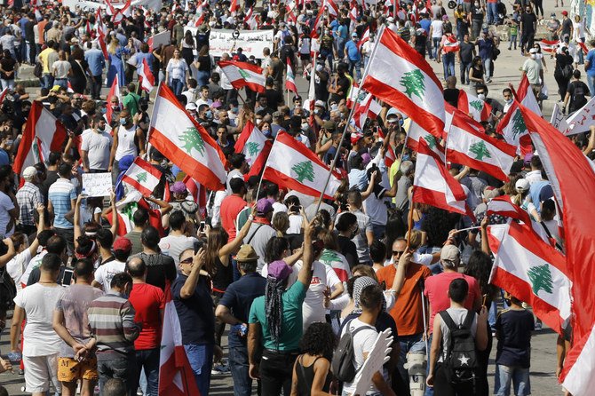 Anti-government protesters hold Lebanese national flags as shout slogans during a protest in downtown Beirut, Lebanon, Saturday, June 6, 2020. (AP)