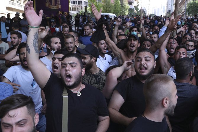 Hezbollah and Amal supporters stand in front of Lebanese army as they shout slogans against anti-government protesters, in downtown Beirut, Lebanon, Saturday, June 6, 2020. (AP)
