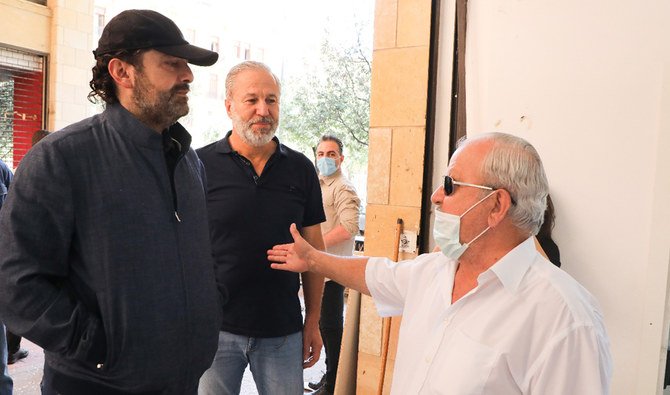 Former Lebanese Prime Minister Saad Hariri talks to one of the owners of damaged shops. (Supplied)