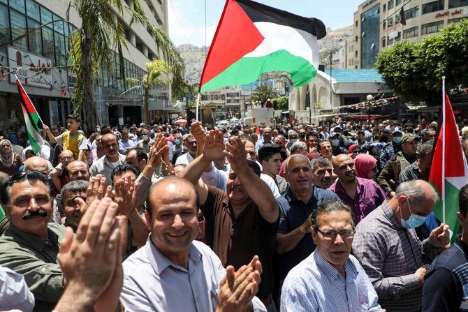 Palestinians, some clad in masks due to the COVID-19 coronavirus pandemic, gather for a protest against Israeli plans to annex parts of the occupied West Bank, in the West Bank city of Nablus on June 3, 2020. (AFP)