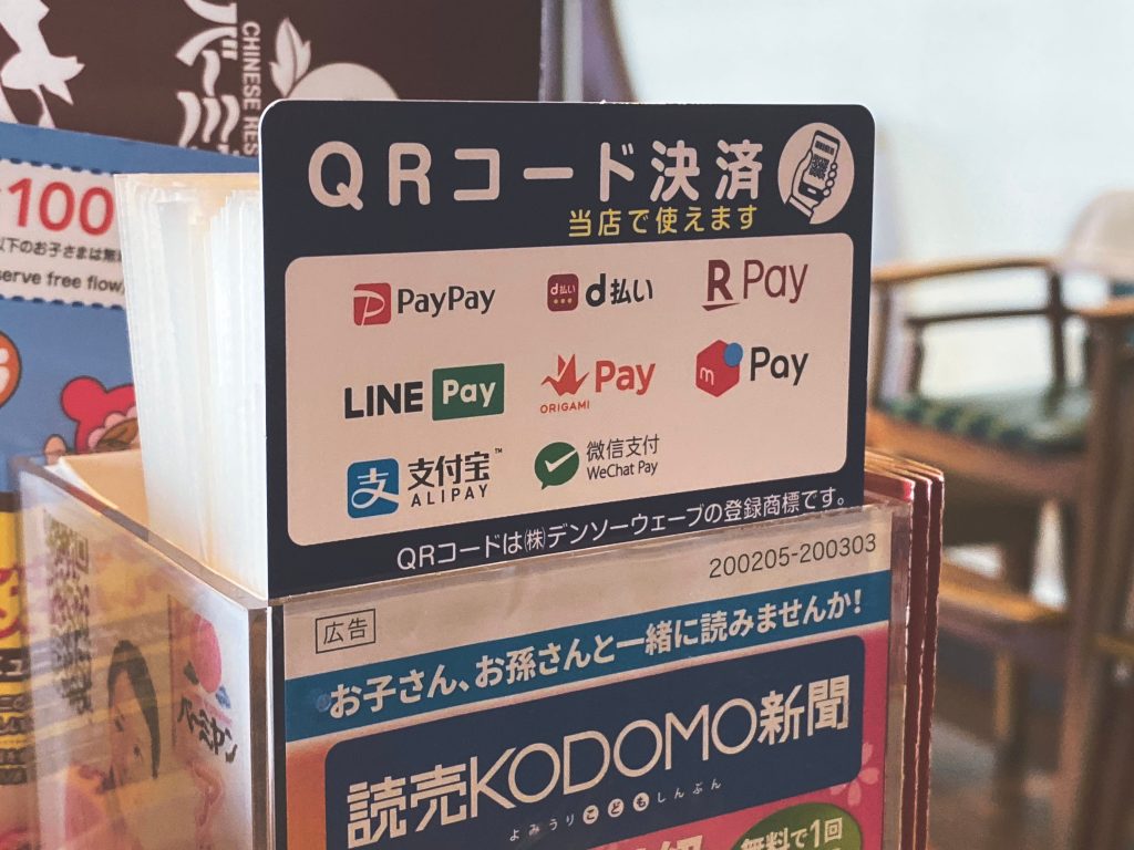A board displaying a list of Cashless Payment systems in Japan. (Shutterstock)