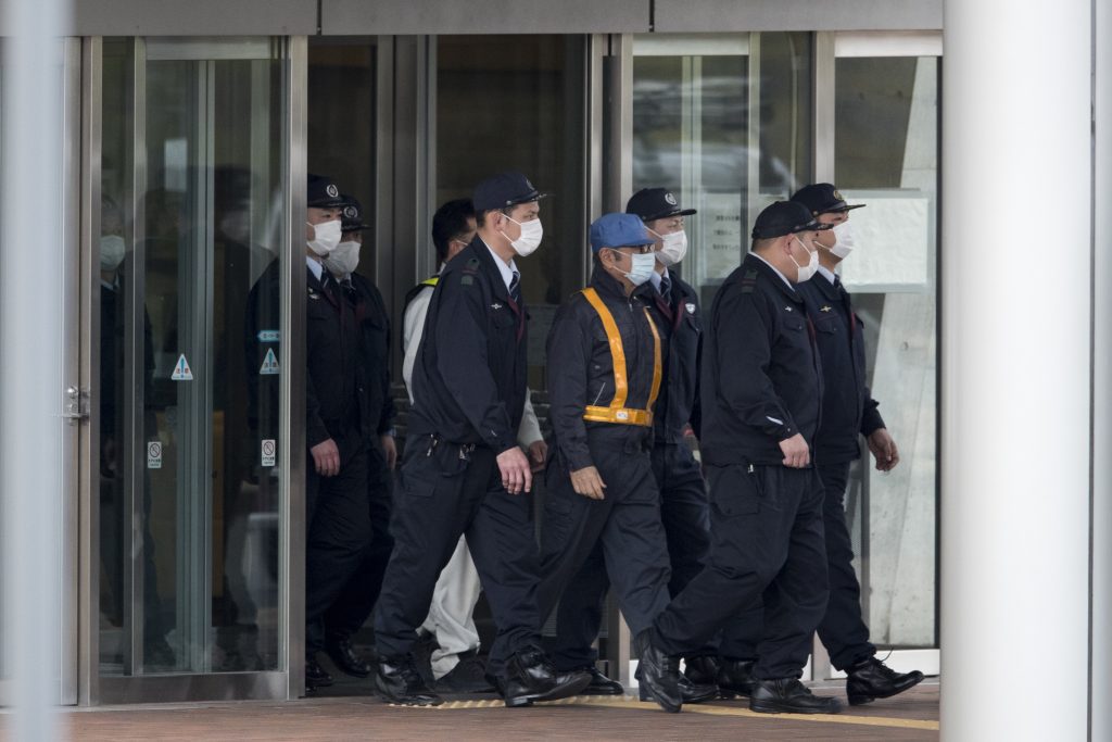 Carlos Ghosn (C) is escorted as he walks out of the Tokyo Detention House following his release on bail in Tokyo,  March. 6, 2019. (AFP)