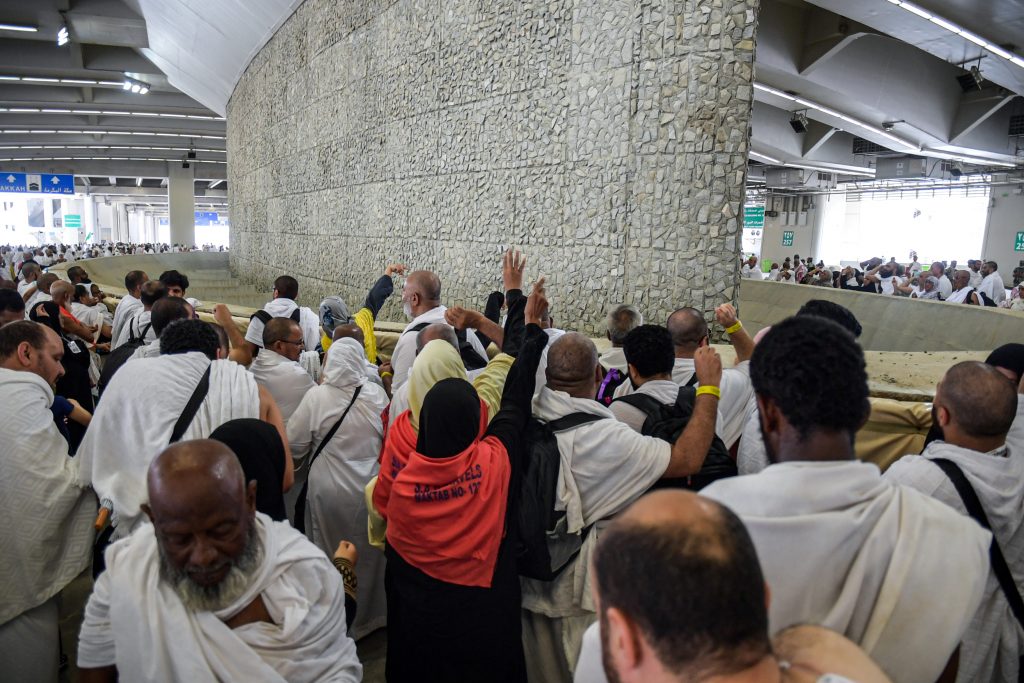 Pilgrims throwing pebbles at a stone wall as part of the symbolic stoning of the devil. (AFP)