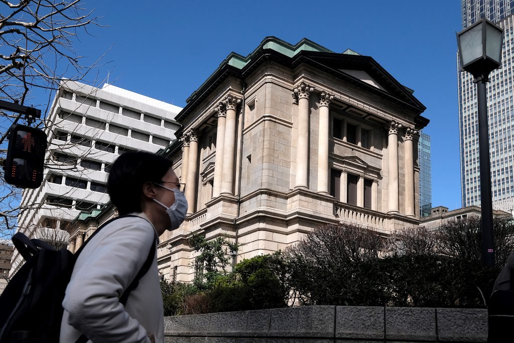 A pedestrian walks in front of the Bank of Japan headquarters in Tokyo. (AFP)