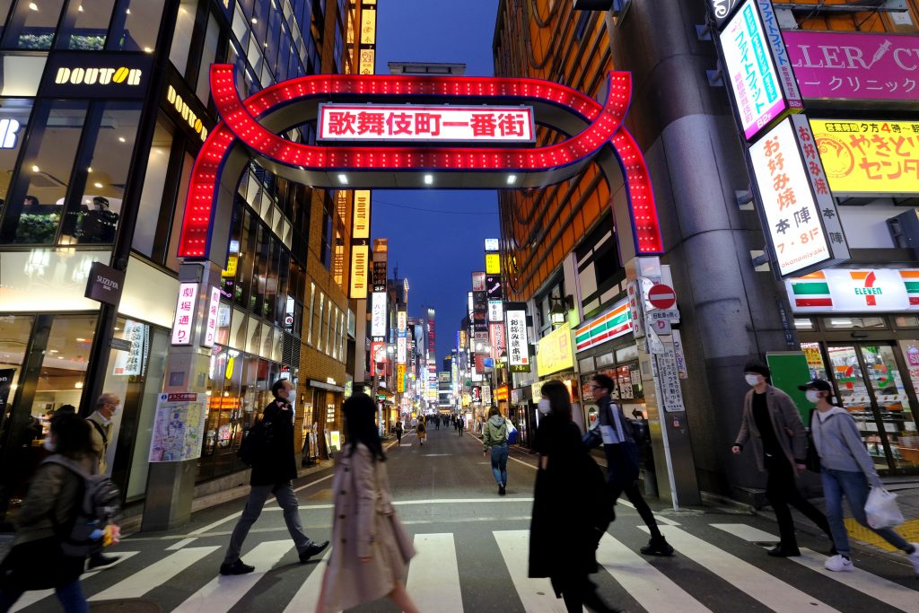 People cross a street at Tokyo's entertainment district Kabukicho, March. 31, 2020. (AFP)
