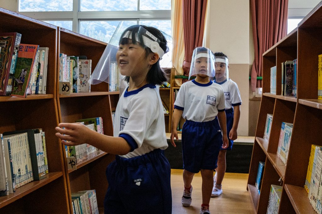 Students wearing face shields visit the library in Kinugawa Elementary School in Nikko, Tochigi Prefecture on June 5, 2020. (AFP)