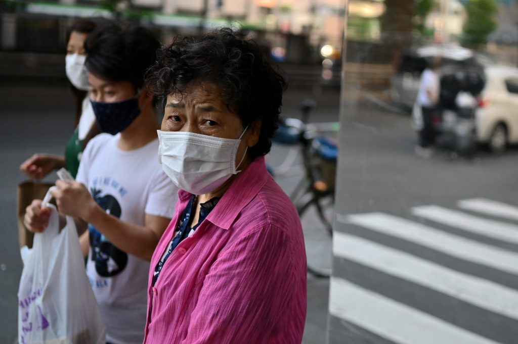 An elderly woman wearing a face mask walks in a street in Tokyo on June 9, 2020. (AFP)