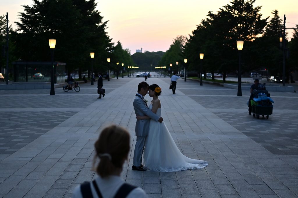 A couple poses for photographs in Tokyo on June 9, 2020. (AFP)