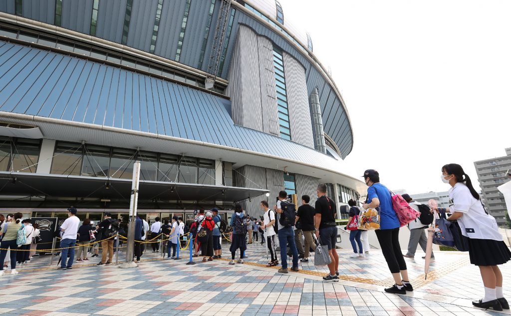 Fans queue with social distancing to enter Kyocera Stadium to watch the Japanese professional baseball match between Orix and Nippon-Ham in Osaka on July 10, 2020. (AFP)
