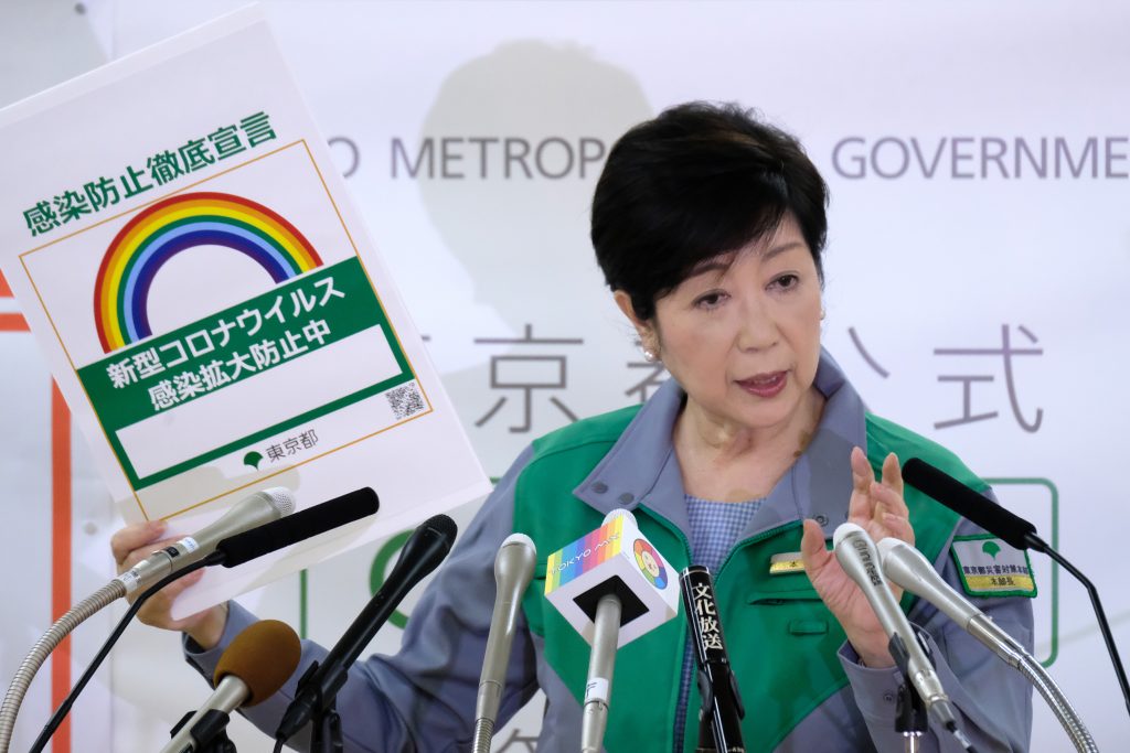Tokyo Governor Yuriko Koike displays a sample sticker declaring that the new coronavirus infection is being prevented, during a press conference at the Tokyo Metropolitan Government office in Tokyo, July 15, 2020. (AFP)