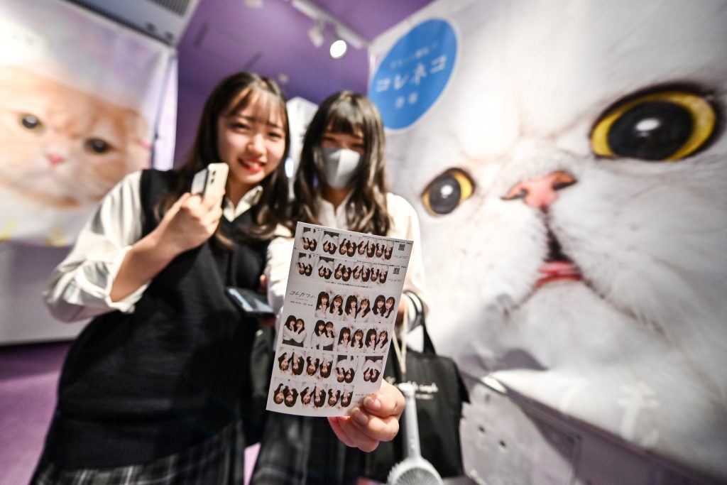 This photo taken on July 21, 2020 shows teenagers displaying the printed images they took at a Japanese style photo booth known locally as