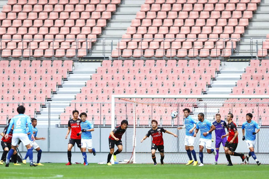  In this March 28, 2020, file photo, players of Nagoya Grampus and Yokohama FC play during a practice game without spectators following the outbreak of the new coronavirus, in Toyota, central Japan. Japanese soccer league is back in action this weekend after a four-month delay because of the coronavirus pandemic. The resumption on Saturday, July 4, 2020, comes as Tokyo reported 107 coronavirus cases on Thursday. (Kyodo News via AP)