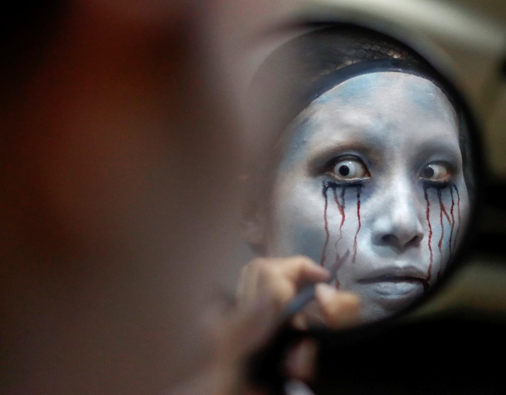 Actor Ayaka Imaide prepares a zombie makeup before her performance at a drive-in haunted house show by Kowagarasetai (Scare Squad), for people inside a car in order to maintain social distancing amid the spread of the coronavirus disease (COVID-19), at a garage in Tokyo, Japan July 3, 2020. (Reuters)