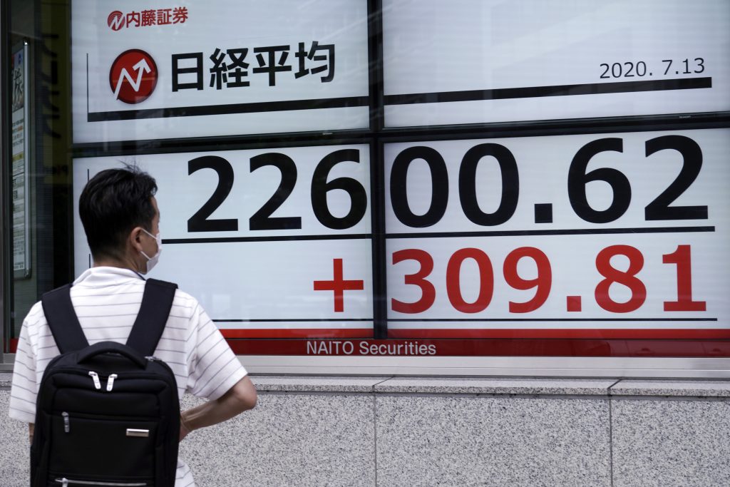 A man wearing a face mask to help curb the spread of the coronavirus looks at an electronic stock board showing Japan's Nikkei 225 index at a securities firm in Tokyo, July. 13, 2020.  (File photo/AP)