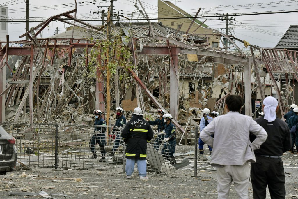 Investigators work at the site of an explosion in Koriyama, Fukushima prefecture, northern Japan Thursday, July 30, 2020. A sudden explosion from a suspected gas leak blew out walls and windows in part of the northern Japanese town Thursday morning. (Kyodo News via AP)