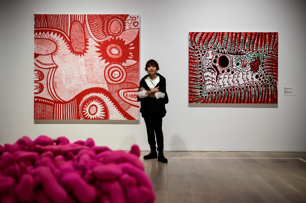 This photo taken on July 30, 2020 shows Mami Kataoka, director of the Mori Art Museum, posing for a photo in front of art by Yayoi Kusama titled 