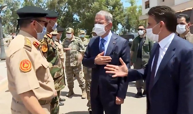 An image grab taken from a video released on July 3, 2020, by the Turkish Defence Ministry shows Turkish Defense Minister Hulusi Akar (C) greeting Libyan officials upon his arrival in Tripoli. (AFP)