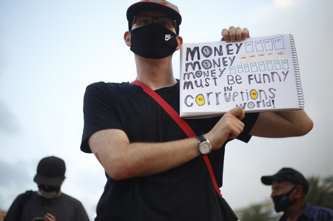 A protesters holds a sign during a demonstration against Israel’s government in Rabin square in Tel Aviv on Saturday, July 11, 2020. (AP)