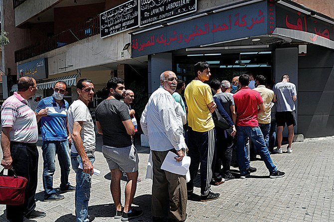 People line up outside an exchange shop to buy US dollars in Beirut. Lebanon’s financial meltdown has thrown its population into a frantic search for dollars as the local currency’s value evaporates. (AP)