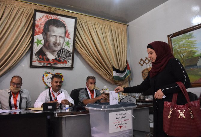A Syrian woman casts her ballot at a polling station in the Nubl neighbourhood of Aleppo on July 19, 2020, during the parliamentary elections. (AFP)