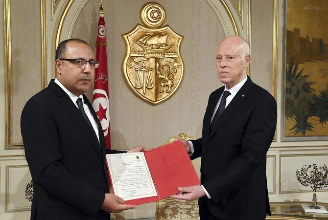 Tunisian president Kais Saied, right, appoints interior minister Hichem Mechichi as the country’s new prime minister on July 25, 2020. (Tunisian Presidency Press Service/AFP)