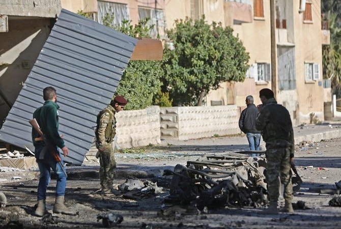 Turkish-backed Syrian fighters stand at the scene of a car bomb explosion in the centre of the town of Ras al-Ain, along the border with Turkey in the northeastern Hassakeh province, on December 4, 2019. (File/AFP)