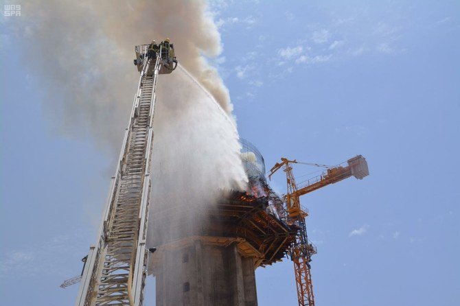 Saudi Civil Defense firefighters suppressing a fire on a tower building in Sakaka on Sunday. (SPA)