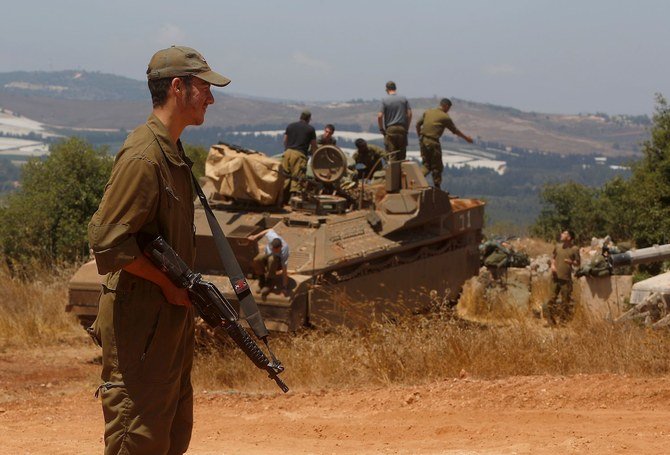 An Israeli soldier stands near a Namer IFV near the town of Avivim in northern Israeli along the border with Lebanon. (File/AFP)