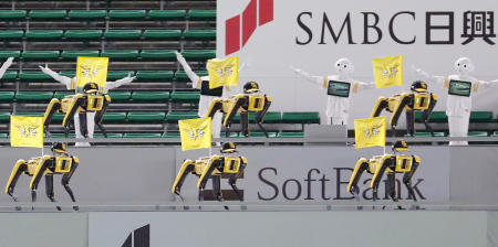 SoftBank Corp's humanoid robots Pepper and Boston Dynamics cheer the teams next to empty spectator seats at a baseball game between SoftBank Hawks and Tohoku Rakuten Golden Eagles in Fukuoka, Japan. (Reuters)