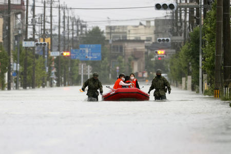 Japan Self Defense Force members rescue residents on a rubber boat on a flooded road hit by heavy rain in Omuta, Fukuoka prefecture, southern Japan Tuesday, July 7, 2020. (Kyodo News via AP)