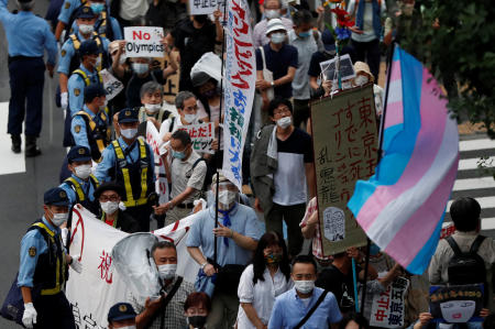 Demonstrators wearing face masks hold signs to protest against the Tokyo 2020 Olympic Games a year before the start of the summer games that have been postponed to 2021 due to the coronavirus disease (COVID-19) outbreak, near National Stadium in Tokyo, Japan, July 24, 2020. (Reuters)