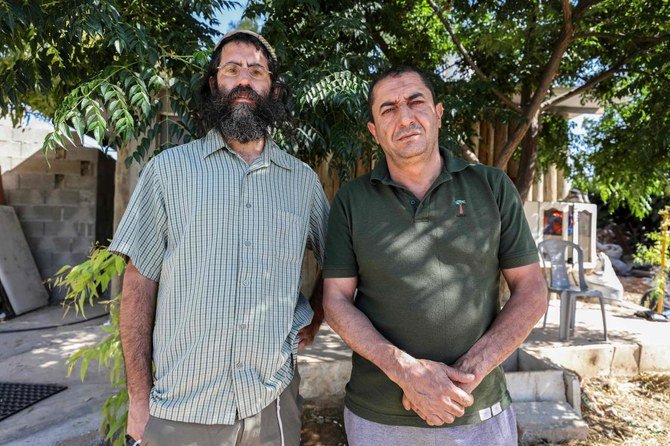 Khaled Abu Awad (R), a Palestinian from Bethlehem, and Shaul Judelman, an Israeli settler from nearby Teqoa settlement, who are both co-directors of movement of settlers and Palestinians called “Shorashim-Judur” (Hebrew and Arabic for “Roots“) and who both published a petition against Israel’s intention to annex parts of the occupied West Bank, pose together for a picture during an interview at the Gush Etzion Junction in the West Bank on July 3, 2020. (AFP/Menahem Kahana)