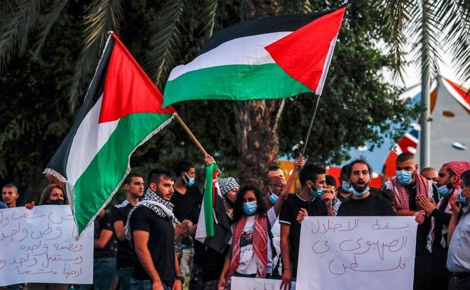 Demonstrators wave Palestinian flags as they gather for a protest against Israel’s plans to annex parts of the West Bank, in the Arab town of Arara in the Wadi Ara region of northern Israel, July 1, 2020. (AFP)