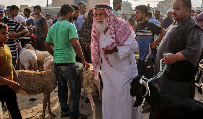 Palestinians buy sacrificial animals at a livestock market ahead of the Eid Al-Adha (feast of sacrifice) in Khan Yunis in the southern Gaza Strip, on July 29, 2020. (AFP)