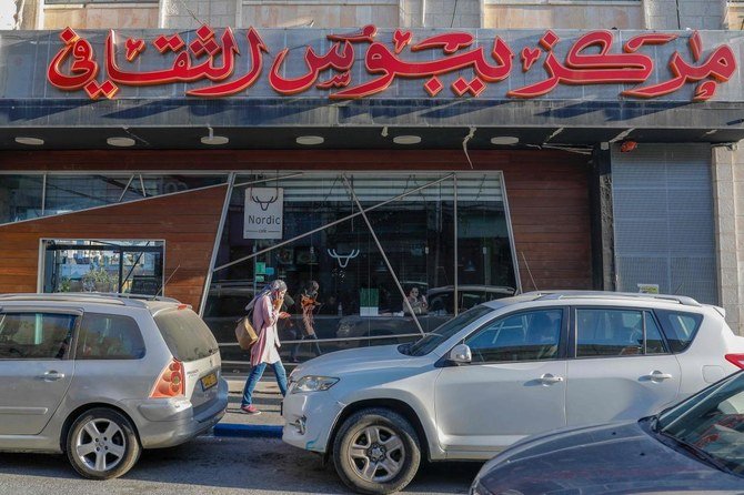 A woman walks past the Yabous Cultural centre that was raided today by Israeli police and tax investigators in east Jerusalem, on July 22, 2020. (AFP)