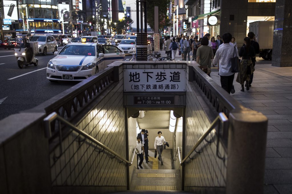 Commuters emerge from a subway crossing in the Ginza neigbourhood of Tokyo on October 1, 2019. (AFP)