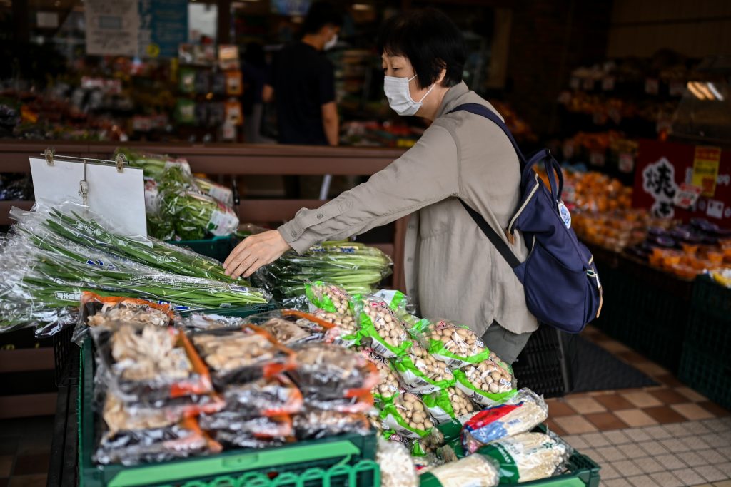 A woman shopping for food individually wrapped in plastic at a supermarket in Tokyo, June. 24, 2020. (AFP)