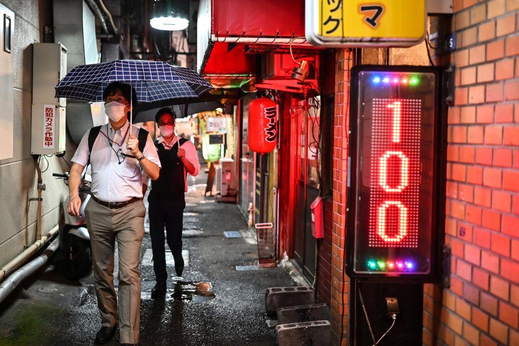 People wearing face masks walk in a street of Tokyo's Oimachi district, July, 21, 2020. (AFP)