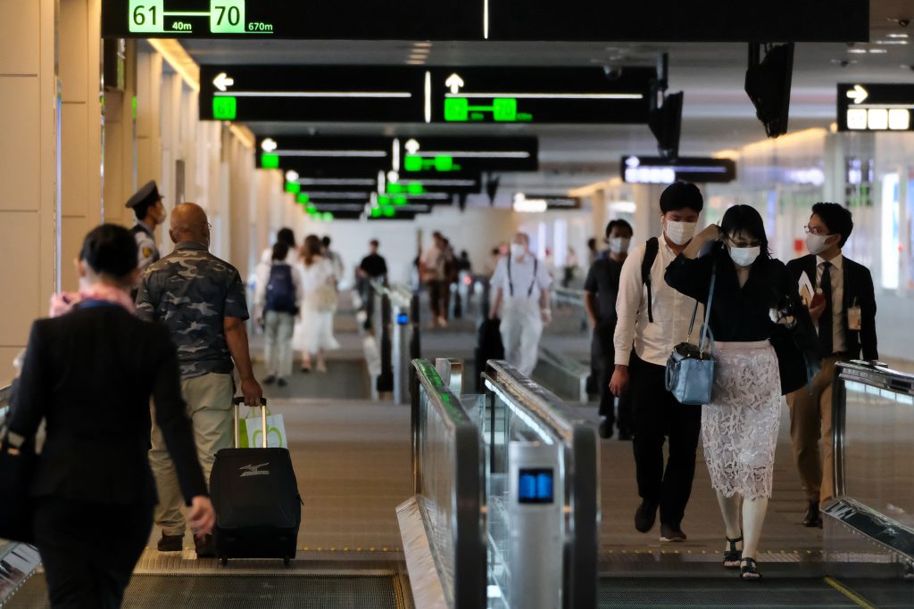 Passengers head to their respective departure gates at the domestic terminal of Tokyo's Haneda airport on July 25, 2020. (AFP)