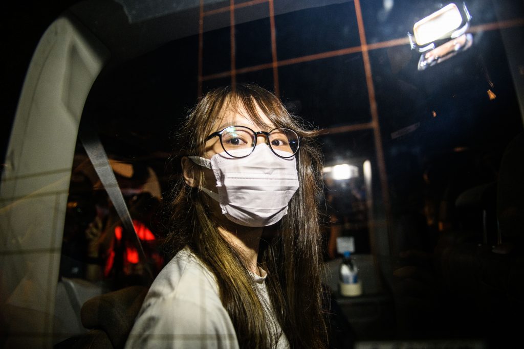 Prominent Hong Kong democracy activist Agnes Chow looks out of a car window while being driven away by police from her home after she was arrested under the new national security law in Hong Kong late on August 10, 2020. (AFP)