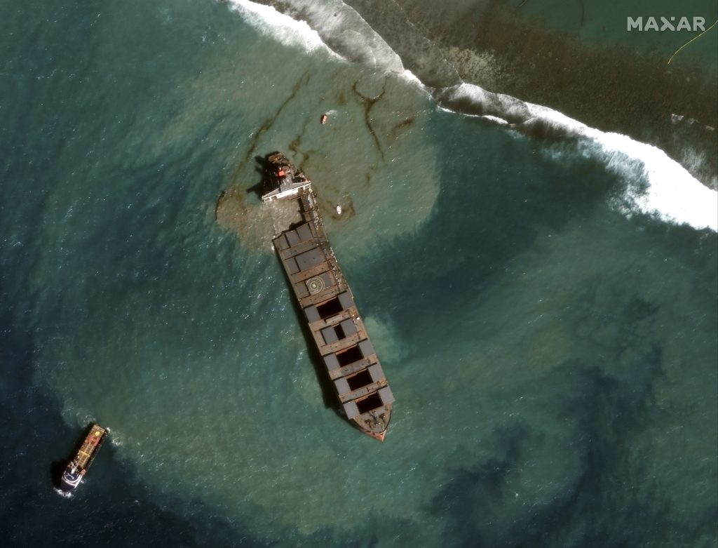This August 18, 2020, handout satellite image obtained courtesy of Maxar Technologies shows a close up view of the MV Wahashio shipwreck and tugs being towed away from the reef off the coast of Mauritius. (AFP)