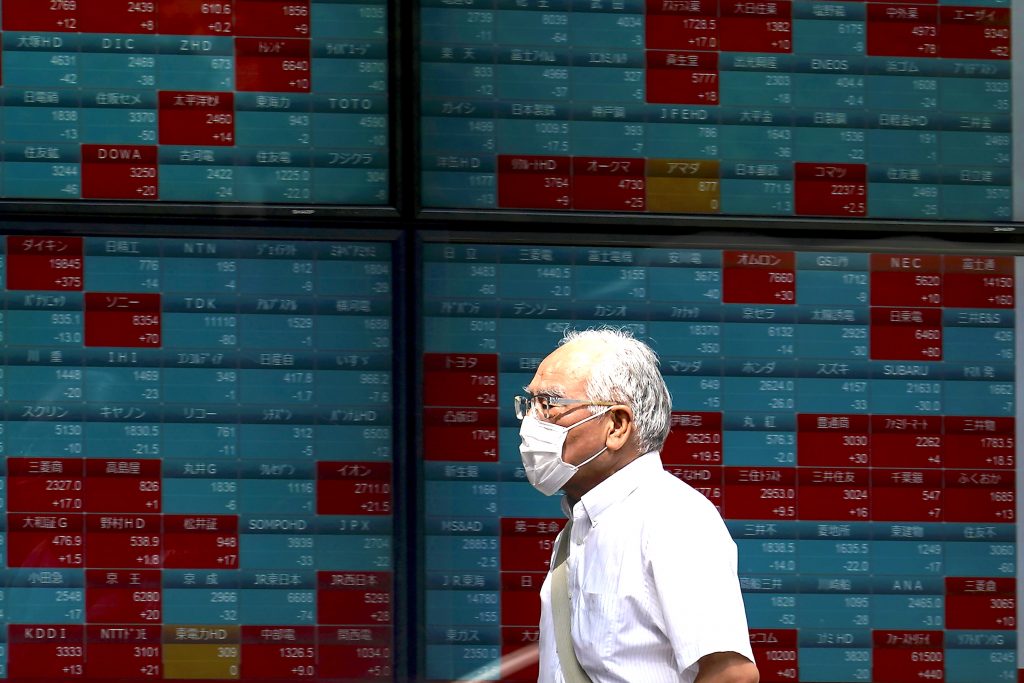 A man walks past an electronic stock board showing Japan's Nikkei 225 index at a securities firm in Tokyo, Aug. 24, 2020. (File photo/AP)