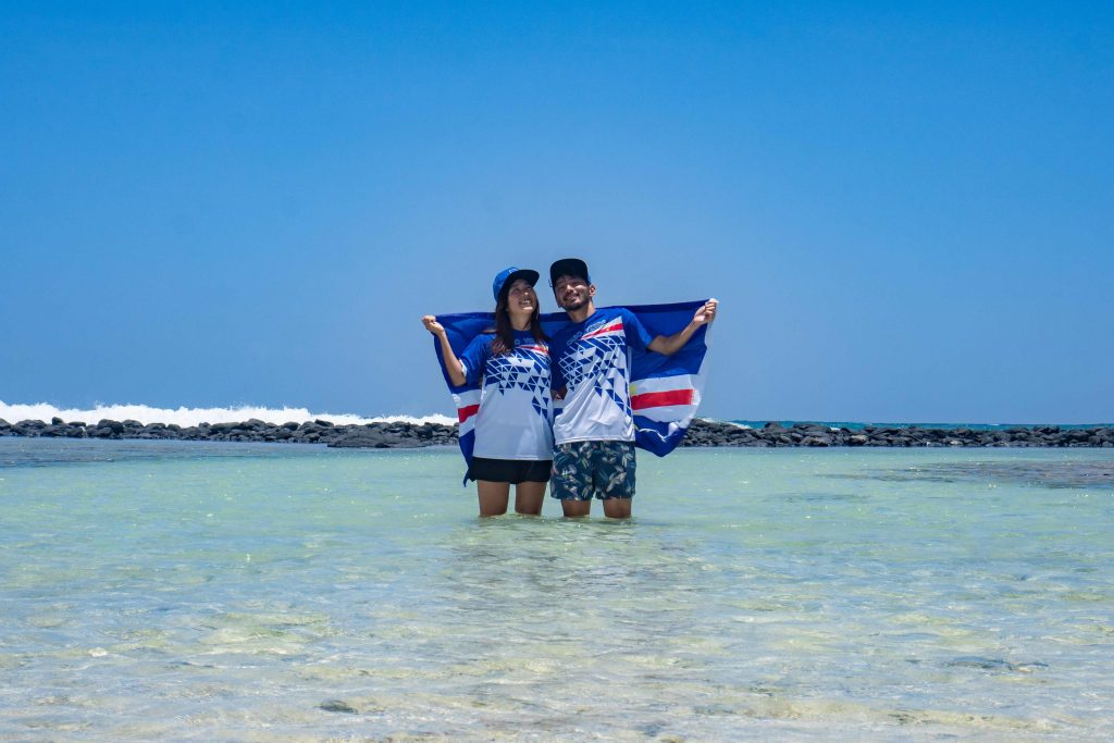 Japanese couple Rikiya (R) and Ayumi Kataoka (L) posing with the official Olympic Cape Verde uniform and national flag as a gift from the National Olympic Committee in Santa Maria in Cape Verde. (instagram/rikiya_trip) 