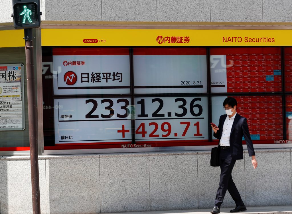 A man wearing a protective mask, following the coronavirus disease (COVID-19) outbreak, walks past a screen showing Nikkei index outside a brokerage in Tokyo, Japan Aug. 31, 2020. (File photo/Reuters)